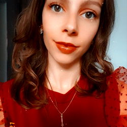 Aurelia, a young woman posing for a photo with a heartfelt smile