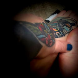 Tattoo artist's hand with a foot in the frame
