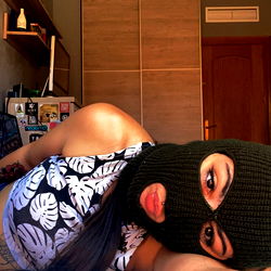 Vibrant Female Model in a Crop Top and Skinny Jeans, Posing on Bed with OnlyFans Sign