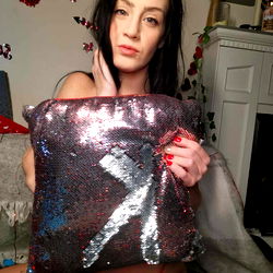 ItsMissKay in a seductive pose with a glittery pillow and red heart background