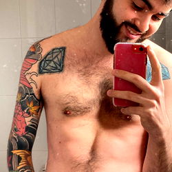 Bearded Man with Tattoos Taking a Mirror Selfie