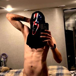 A Shirtless Man with a Masked Head in His Hand
