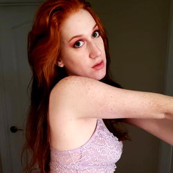 Red-haired model Anya, captivating in a purple lace bralette on OnlyFans