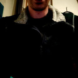 A young man playfully with his tongue out in a selfie. 