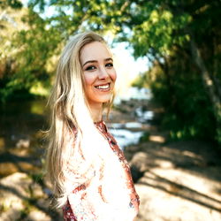 A joyful outdoor portrait of a young woman, named Sweet_Caroline. Her cheerful expression and the beautiful natural setting create an uplifting atmosphere.