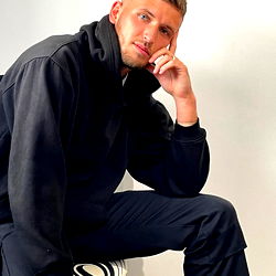 Stylish Man in a Casual Outfit Posing with a Slightly Thoughtful Expression