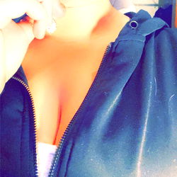 Amorsita, a Young Female with Ample Cleavage and a Ring on Her Finger, Taking a Selfie while Smiling at the Camera