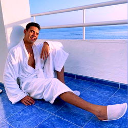 ManiManitas in a relaxed pose on a patio by the ocean