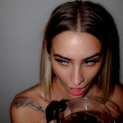 A Close-Up of a Female Model with Her Mouth Open, Holding a Coffee Cup on OnlyFans