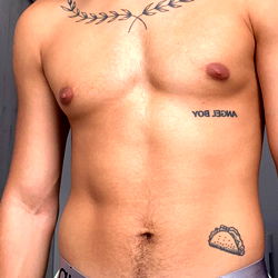 A Toned OnlyFans Model in a Tank Top, Standing Shirtless with a Tattoo and Tattoo Cover-up