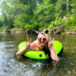 J in a playful pose with a river