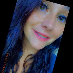 Beautiful woman with long brown hair, blue eyes, and pink lipstick posing for a portrait.