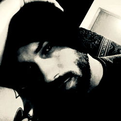 A young man with a beard and tattoo