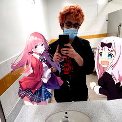 A Funny Photo of a Person Posing with Anime Figure and Poster