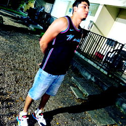 A Young Man in a Shirt and Shorts Standing Outdoors