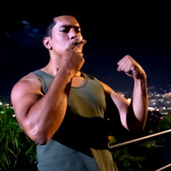 Andres Arrieta, a Bodybuilder Puffing on Cigarette and Striking Pose