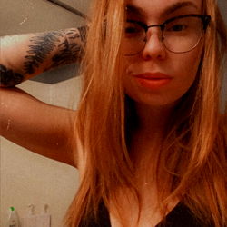 A Playful OnlyFans Model with Red Hair and a Devilish Expression