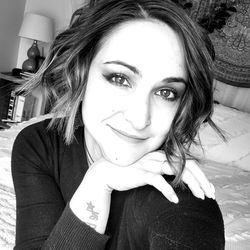 Stylish Woman with Tattoo Sitting on Bed