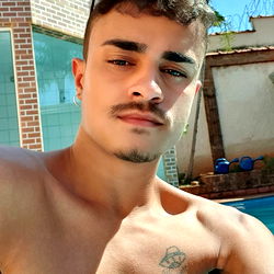 A Shirtless Young Man Taking a Selfie by the Pool