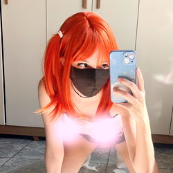 Anime-inspired cosplayer in vibrant red hair and mask
