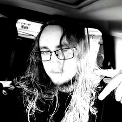 Ax, a bearded man in glasses, gesturing peace with his right hand