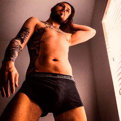 Tattooed Model in Black Boxers, Looking Confident