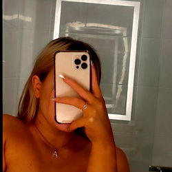 AlleyKatt, an OnlyFans model, captured in a candid moment in a bathroom