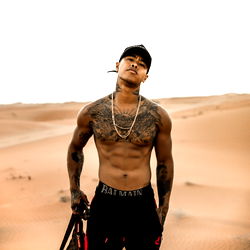 Famous Onlyfans Model Starboy Uk, Standing on Sand with Guns and Shoes