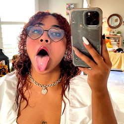 OnlyFans Model Merika: Posing with Phone, Showcasing Mouth and Tattoo, Tagged With #SexyOnlyFans