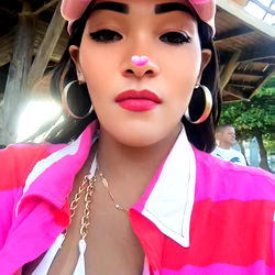 Stylish Aramata Pimenta posing in front of a rustic backdrop