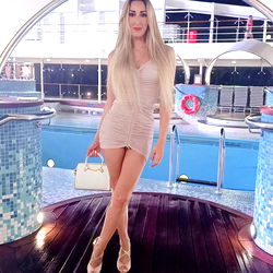 A Model Posing on a Platform with Blue Water and Sky Background