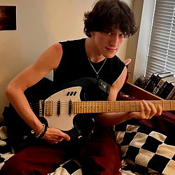 A person playing a guitar in a room