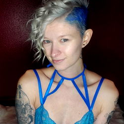 Vogue-inspired Ally, a OnlyFans model, strikes a pose in a blue bra and matching panties with a tattoo on her chest