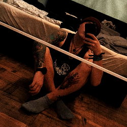 Stylish Tattooed Adult Sitting in Room