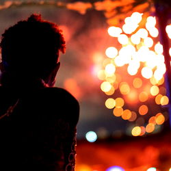 A person at a night event with lights in the background