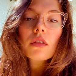 Long-haired woman with glasses in outdoor setting