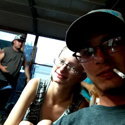 A Moment of Two Adults Sharing a Cigarette Outdoors