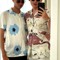 Fashionable young men in a mirror, sharing a social moment.