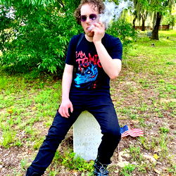 Smoking in a relaxed pose in an outdoor setting