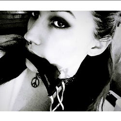 A striking black and white portrait of a person wearing a muzzle, set against a simple background.