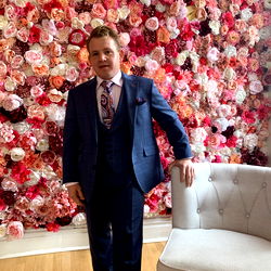 Mister Manager posing near a floral backdrop