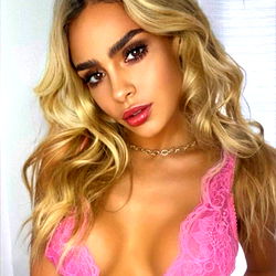 OnlyFans Model with Tight Outfit, Posed in Front of Backdrop