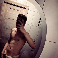 Fit Male Model Showcasing Body in Bathroom Mirror