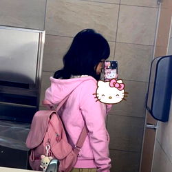 Young Girl in Pink Hoodie at Restroom Mirror