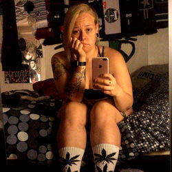 A Young Woman with Short Hair Sitting on a Bed