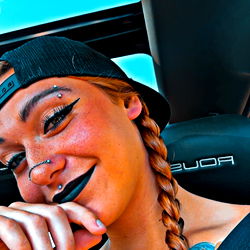 B. - Smiling with Finger on Mouth