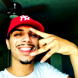 Smiling Guy in Hat, Shirt, and Cap Signaling