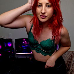 Lonely Gamer Gal: Red-haired Australian model in a green lace bra and black skirt