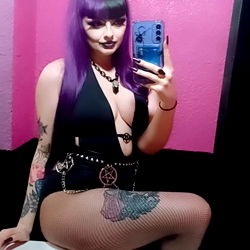 Gothic Model in Fishnet Bodysuit Posing for Selfie