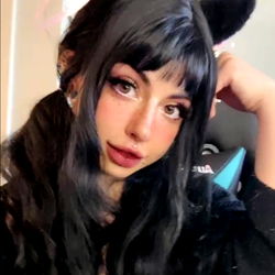 Auburn-haired cosplayer with cat ears, sitting and smiling